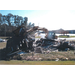 bulldozer cleaning up destroyed house