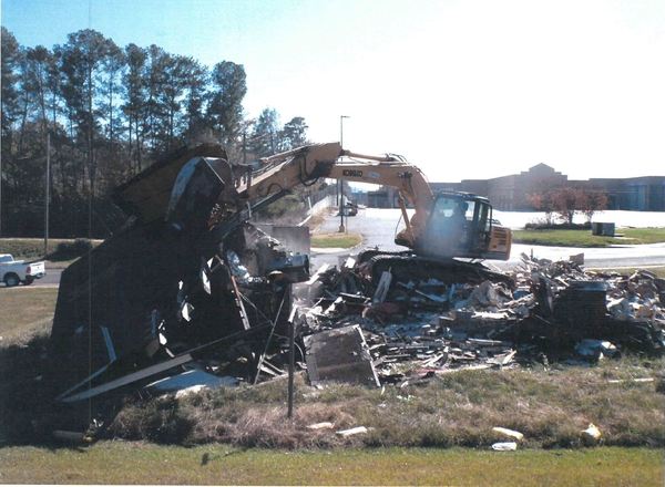 bulldozer cleaning up destroyed house