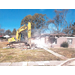 bulldozer tearing down tornado damaged home