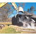 up close view of bulldozer tearing down damaged home