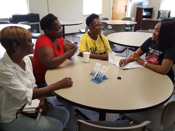 three female residents talking with female performing the HIV tests